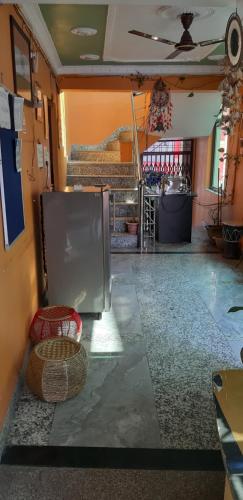 a living room with a refrigerator and a table at MANIK GUEST HOUSE in Rishīkesh