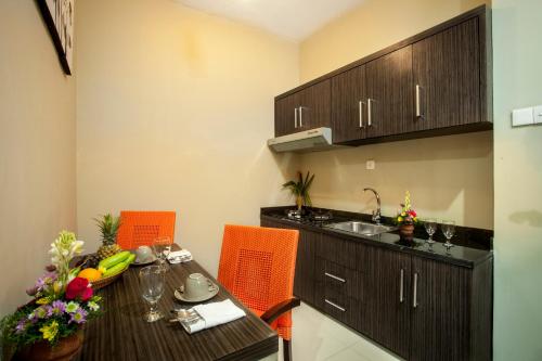 a kitchen with a dining table and a sink at ABISHA Resort Jimbaran in Jimbaran