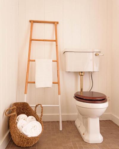 a bathroom with a toilet and a basket of towels at Ragnar Glamp Koknese in Koknese