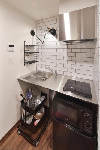 a kitchen with a sink and a stove at Stylewood Nishi-Shinjuku by Tranova in Tokyo