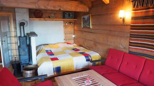 Habitación con cama, sofá y mesa. en Klævold utleigehytte en Klevoll
