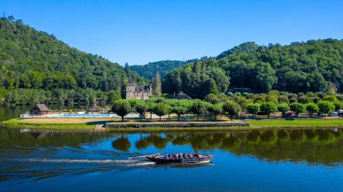a group of people in a boat on a river at Camping Le château du gibanel in Saint-Martial-Entraygues
