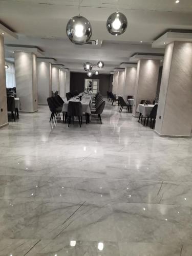 a dining room with tables and chairs in a building at Hotel Balkan in Gabrovo