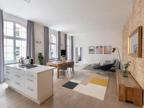 a kitchen and living room with a stove and a table at limehome Berlin Kopenhagener Straße in Berlin