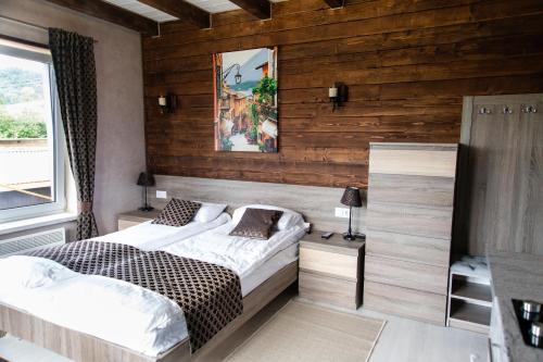 a bedroom with two beds and wooden walls at Садиба Кичера Gold in Mizhhirʼʼya