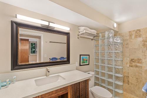 a bathroom with a sink and a toilet and a mirror at Kanai A Nalu Resort 114 in Wailuku