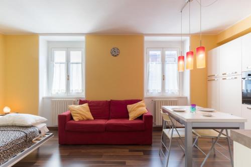 a living room with a red couch and a table at Casa Anna Giulia in Castione della Presolana