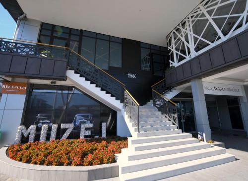 ein Gebäude mit Treppen und Blumen davor in der Unterkunft Hotel Kole in Čačak