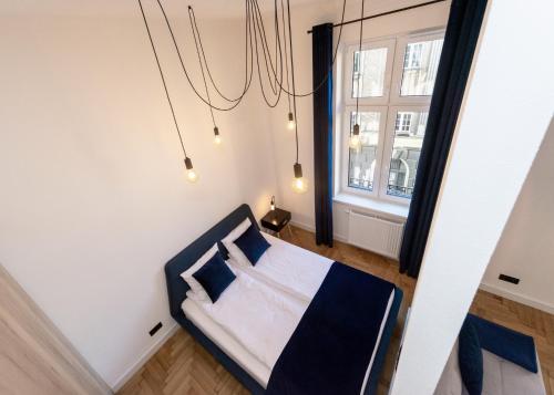 a bedroom with a bed with blue pillows and a window at Studio Matejki C in Bielsko-Biala