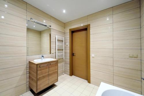 ein Bad mit einem Waschbecken, einer Dusche und einem Spiegel in der Unterkunft Valensia Apartment in Druskininkai