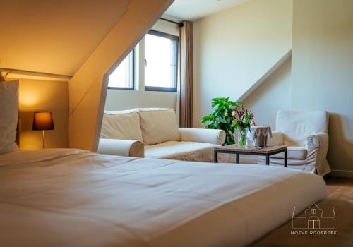 una camera d'albergo con letto e soggiorno di Hoeve Roosbeek a Zepperen