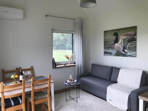 a living room with a couch and a table at PAMIŠKĖ BOUTIQUE SPA in Jokūbavas