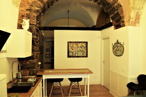 una cucina con tavolo e lavandino in una stanza di Casa di Tano a Catania