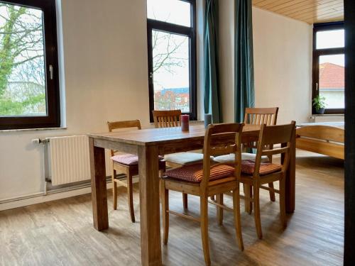 ein Esszimmer mit einem Holztisch und Stühlen in der Unterkunft Das blaue Türchen - Wohnung mit Beamer und Kicker in Bremerhaven