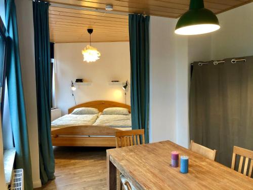 ein Schlafzimmer mit einem Bett und einem Tisch in einem Zimmer in der Unterkunft Das blaue Türchen - Wohnung mit Beamer und Kicker in Bremerhaven