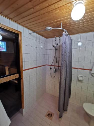 a bathroom with a shower with a shower curtain at Luulampi - Studio in the center of Saariselkä in Saariselka