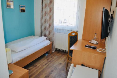 a small room with a bed and a desk at Hotel Discovery in Stuttgart