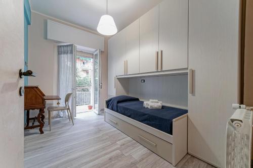 Genova Sturla Elegant Apartment في جينوا: غرفة نوم بسرير وطاولة ومكتب