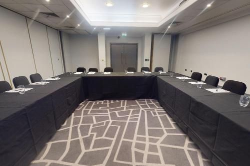 a large meeting room with a long table and chairs at Village Hotel Birmingham Dudley in Dudley