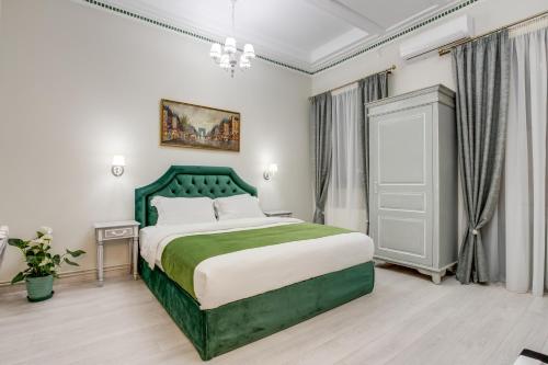 a bedroom with a bed and a dresser at Pandrosos Divine Suites in Athens