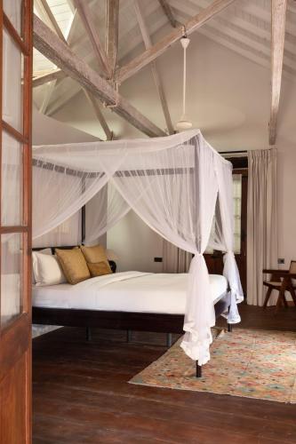 a bedroom with a bed with a canopy at The Fort Printers in Galle