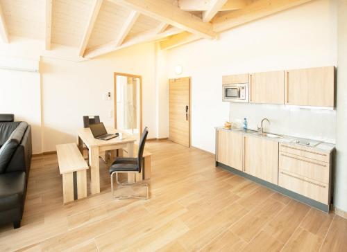 a kitchen and a living room with a table and a couch at Stadthotel Donauwörth in Donauwörth