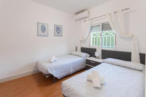 a bedroom with two beds and a window at Palomas in Denia
