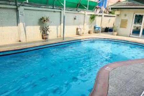 Room in Lodge - Hi Point Hotel and Suites - Standard في لاغوس: مسبح ازرق كبير في مبنى