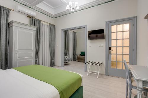 a bedroom with a green bed and a table at Pandrosos Divine Suites in Athens
