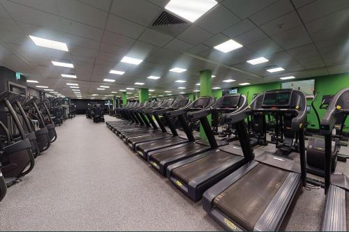 a gym with rows of treadmills in a room at Village Hotel Birmingham Dudley in Dudley