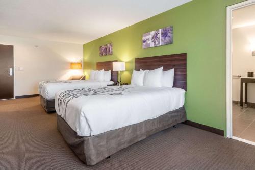 two beds in a hotel room with green walls at Sleep Inn Boardman in Boardman