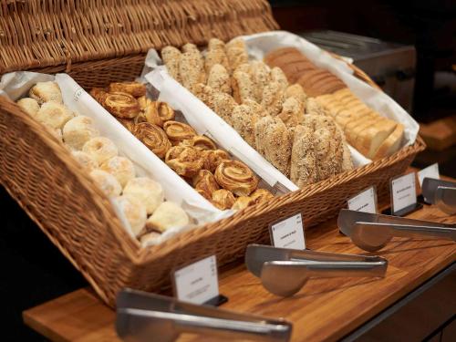 a wooden table topped with lots of different types of bread at Pullman Sao Paulo Ibirapuera in São Paulo