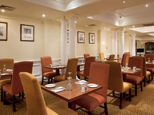 a dining room with tables and chairs in a room at Winchester Wessex Hotel by Sunday in Winchester