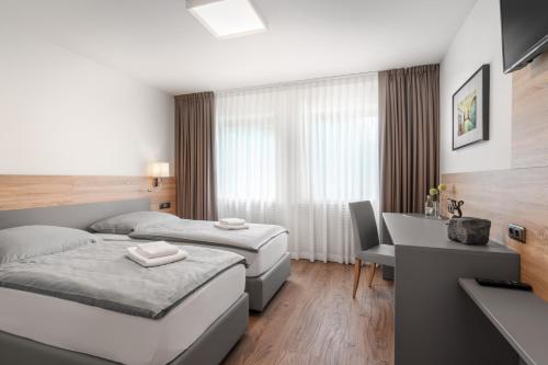 Habitación de hotel con 2 camas y escritorio en Ambiente Hotel Papenhof en Elze