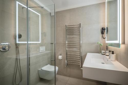 La salle de bains est pourvue de toilettes, d'un lavabo et d'une douche. dans l'établissement Ambiente Hotel Papenhof, à Elze