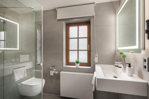 a bathroom with a sink and a toilet and a shower at Ambiente Hotel Papenhof in Elze