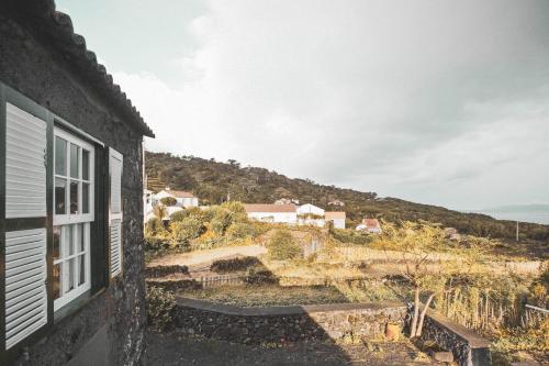 a window of a house with a view of the ocean at Adegas do Pico in São Roque do Pico