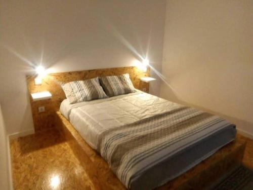a bedroom with a bed with two lights on it at Impeccable 1 Bed Villa in Ribeira Grande in Ribeira Grande
