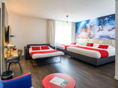 a hotel room with two beds and a couch at ibis Styles Almere in Almere