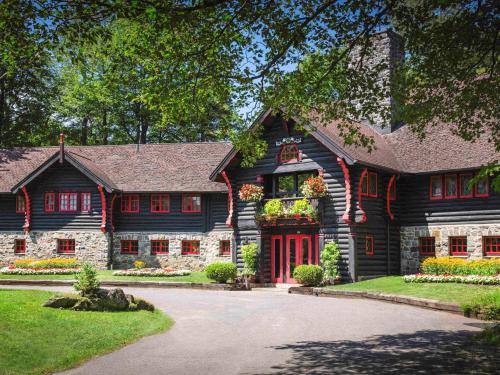 Cette maison en rondins est dotée d'une porte rouge. dans l'établissement Fairmont Le Chateau Montebello, à Montebello