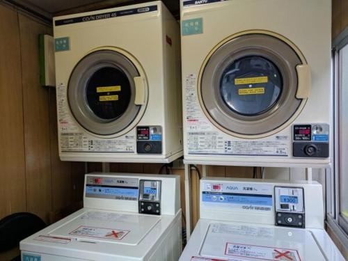 three washing machines are lined up in a room at Hotel Harbour Yokosuka - Vacation STAY 86062 in Yokosuka
