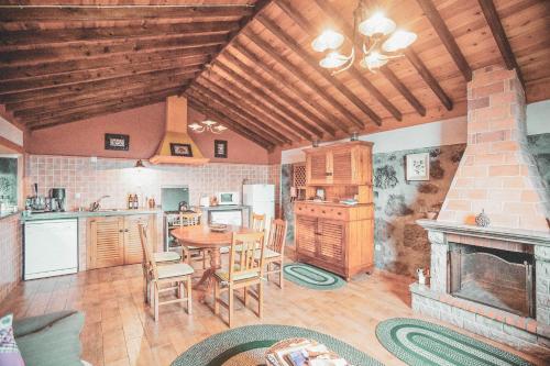 a kitchen and dining room with a table and a fireplace at Adegas do Pico in São Roque do Pico