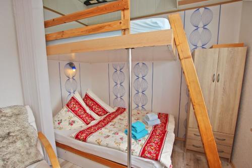 WarenshofにあるFerienhaus Waren SEE 6421の二段ベッド(赤と白の枕、はしご付)