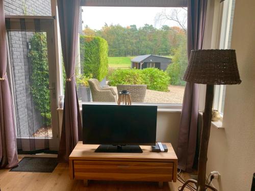 a computer monitor on a table in front of a window at Bed and Breakfast De Paalberg in Hoenderloo