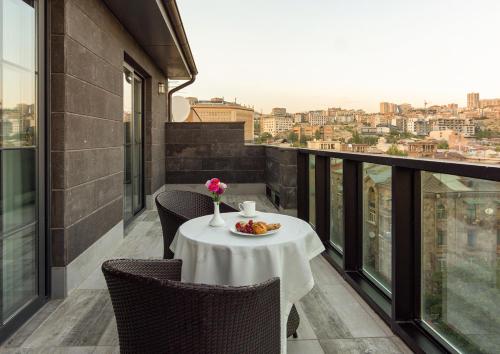 uma mesa numa varanda com um prato de comida em Dave Hotel Yerevan em Yerevan