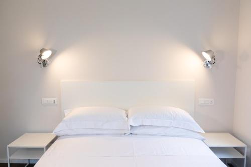 a bedroom with a white bed with two lights on it at flaminia354 - B&B in Rome