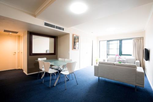 a living room with a table and a couch at HarbourView Apartment Hotel (now Arrow on Spencer) in Melbourne