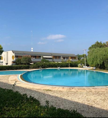 a large blue swimming pool in front of a building at Cozy Apartment TAM in Bari