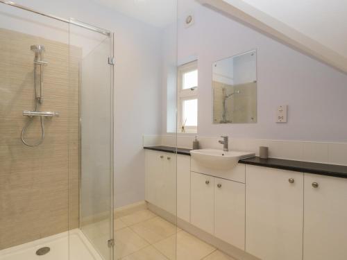 a white bathroom with a sink and a shower at Oakdene in Stratford-upon-Avon