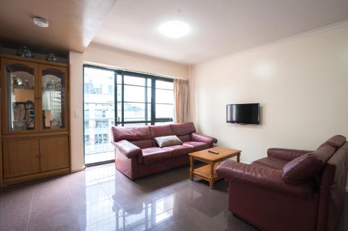 a living room with two couches and a tv at HarbourView Apartment Hotel (now Arrow on Spencer) in Melbourne